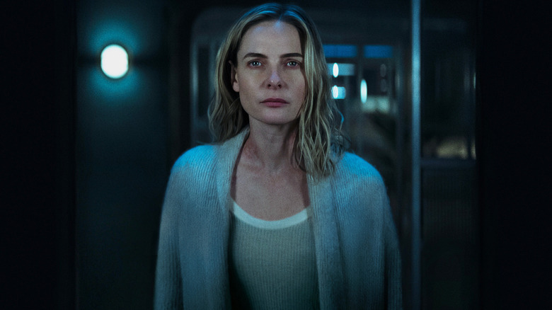 Rebecca Ferguson as Juliette Nichols wearing a robe and looking uncertainly at her reflection in a mirror in Silo
