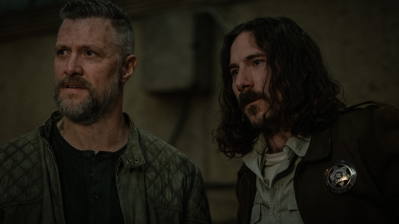 Shane McRae as Knox standing next to Billy Postlethwaite as Deputy Hank in Silo