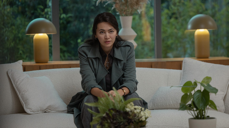 Jessica Henwick as Helen Drew sitting on a couch and looking forward in Silo