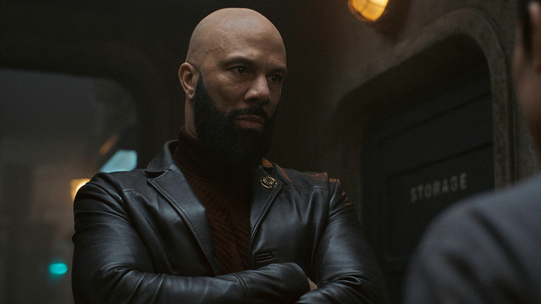 Common as Robert Sims crossing his arms and staring someone down with an intimidating expression on his face in Silo