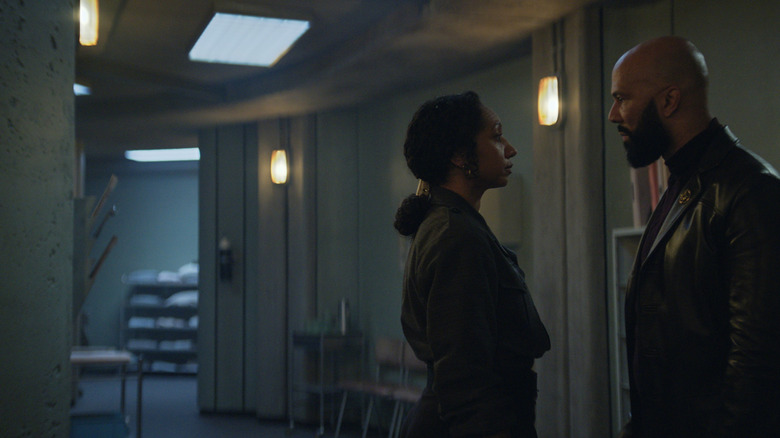 Alexandria Riley as Camille Sims standing opposite Common as Robert Sims in an empty hallway in Silo