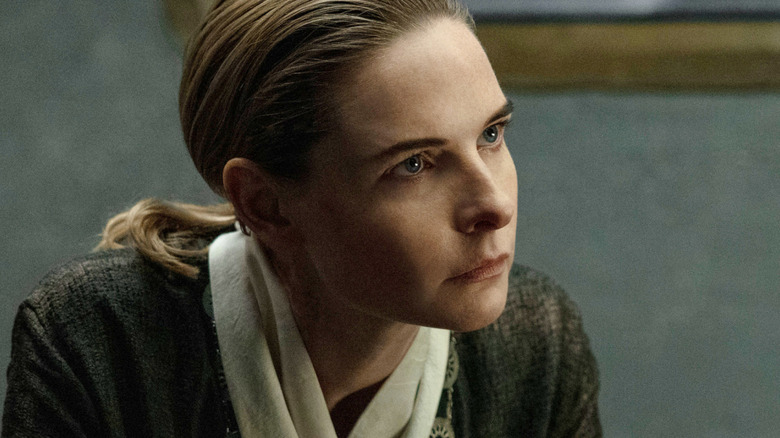 Rebecca Ferguson as Juliette Nichols seated opposite Tim Robbins as Bernard Holland in Silo