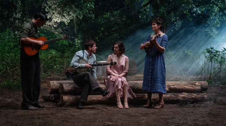 Peter Dreimanis as Burt, Jack O'Connell as Remmick, and Lola Kirke as Joan serenading  Hailee Steinfeld's Mary with folk music in a forest