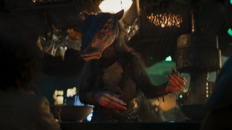 A six-eyed alien inspects a former Republic credit in Star Wars: Skeleton Crew