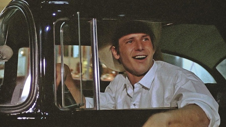 Harrison Ford como Bob Valva mirando arrogantemente por la ventana de su auto en American Graffiti