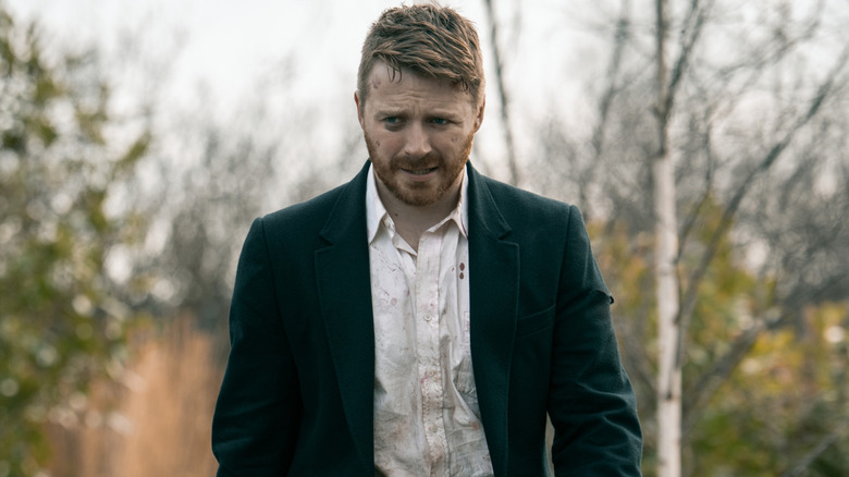 River Cartwright looking beaten up against a forest backdrop in Slow Horses Season 6