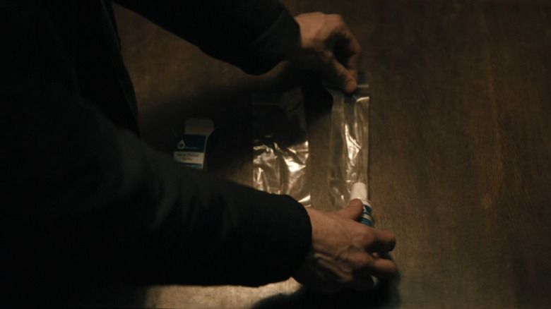 Jim laying down his poison apparatus on a table in Slow Horses Season 6