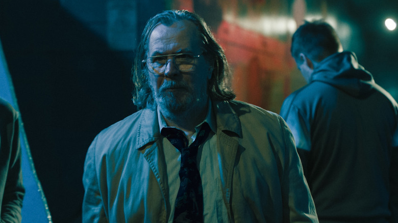 Jackson Lamb (Gary Oldman) in his trenchcoat with River (Jack Lowden) stood with his back to him in Slow Horses