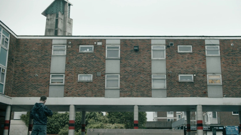 Rob Trew (Edward Davis) aims a rifle in a shopping center in Slow Horses