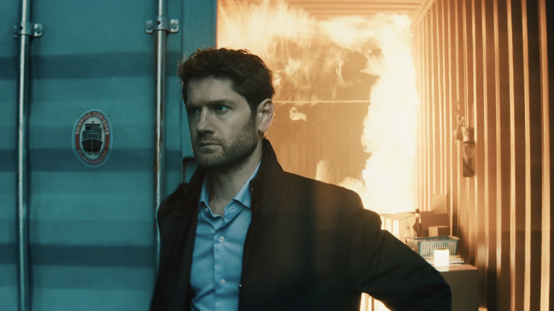 Jim walks out of a burning shipping container in Slow Horses Season 6