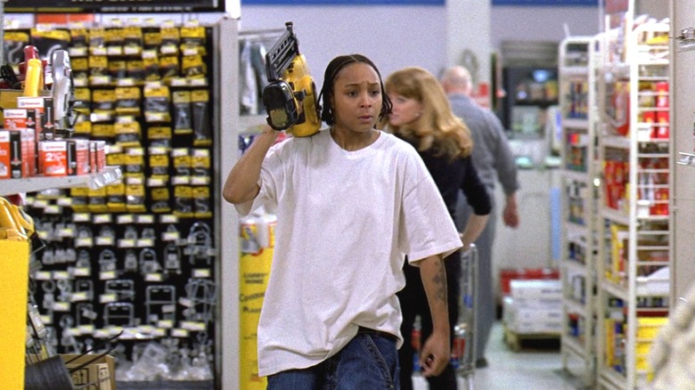 Felicia Pearson as Snoop walking through a hardware store and holding up a nail gun in The Wire