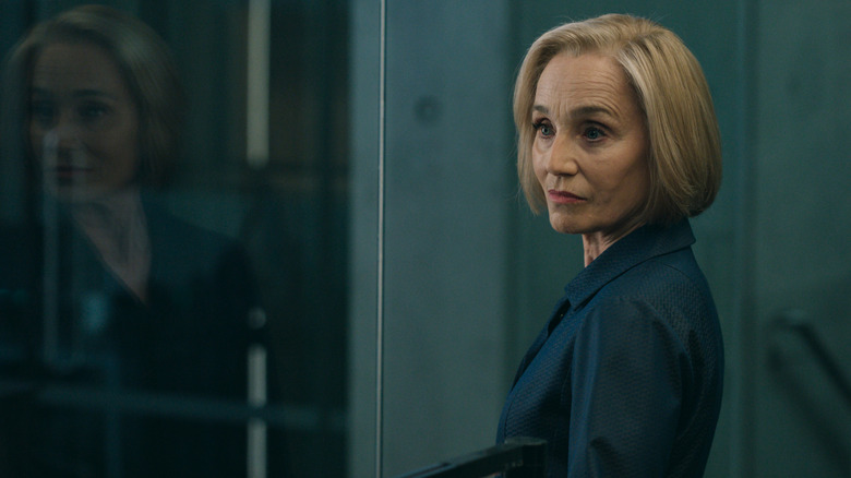Kristin Scott Thomas' Diana Taverner stands by a large pane of glass in Slow Horses