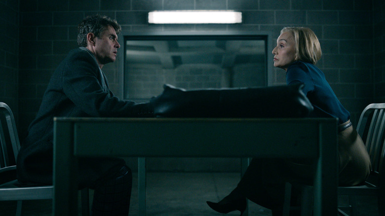 Kristin Scott Thomas as Diana Taverner sitting across Paul Higgins as Struan Loy in an interrogation room in Slow Horses