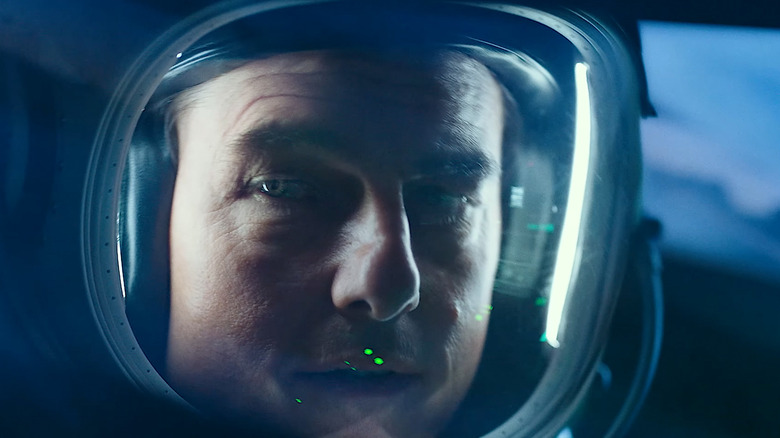 Tom Cruise's Pete Mitchell looks down while wearing his pilot's helmet in Top Gun Maverick