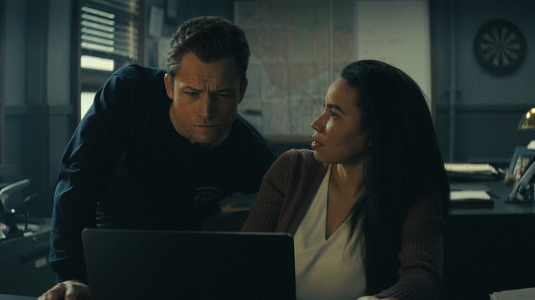 Taron Egerton as Dave Gudsen looks over the shoulder of Jurnee Smollett as Detective Michell Calderon in Smoke