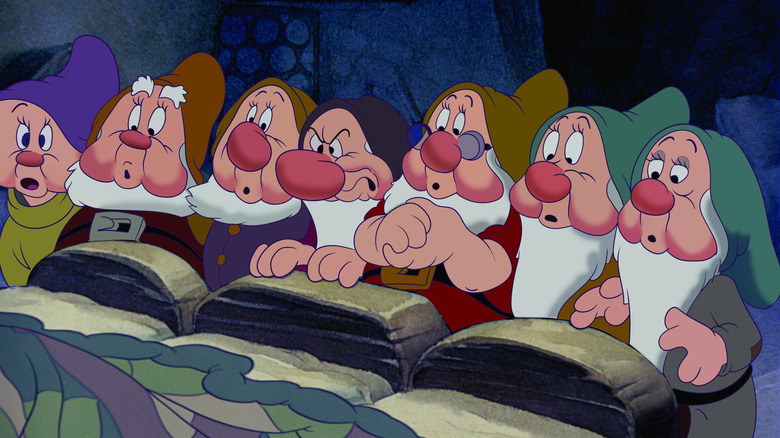 The seven dwarfs standing at the end of the bed in Snow White and the Seven Dwarfs