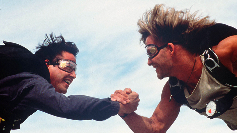 Johnny Utah (Keanu Reeves) and Bodhi (Patrick Swayze) hold hands mid-air in "Point Break"