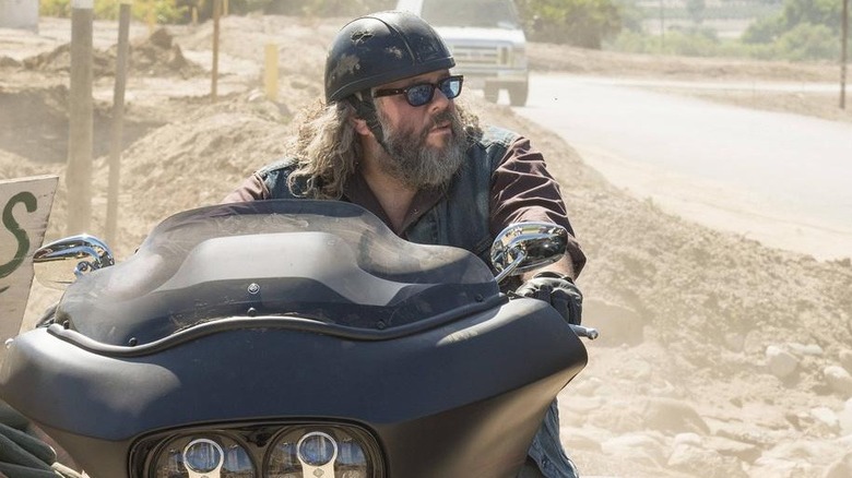 Mark Oone Junior quando Bobby Elvis está sentado sua motocicleta no lado do caminho para os filhos do ministro