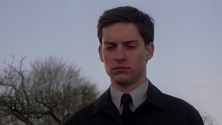 Tobey Maguire's Peter parker looks sad as he stands outside in Spider-Man