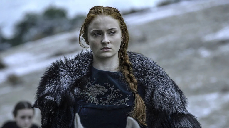 Sansa portant des fourrures Stark et un écusson sur un cheval dans Game of Thrones