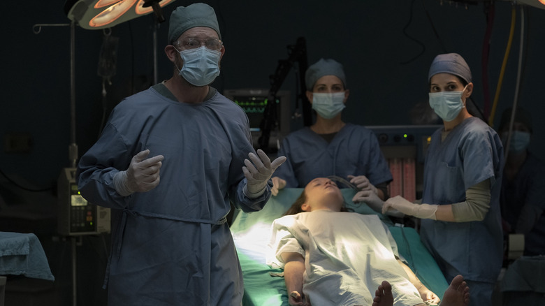 Ellie lies on an operating table surrounded by doctors in The Last of Us