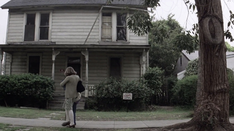 Jamie Lee Curtis' Laurie Strode stands outside the Myers House in Halloween