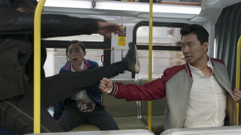 Awkwafina as Katy watching as Simu Liu as Shang-Chi fights someone on a bus in Shang-Chi and the Legend of the Ten Rings