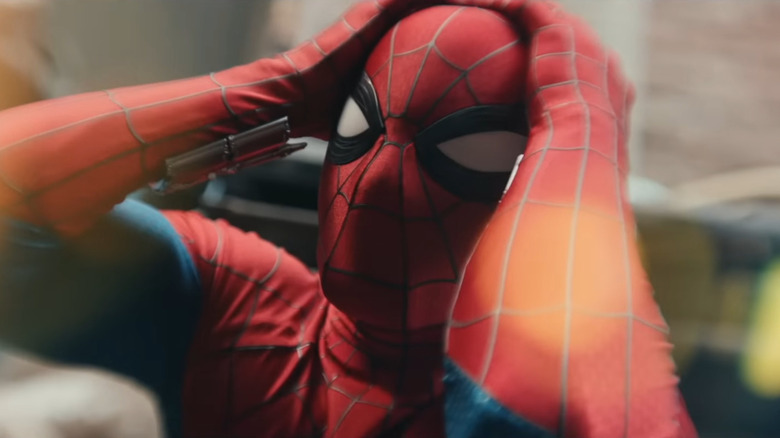 Tom Holland as Peter Parker wearing his superhero suit and covering his head in his hands in Spider-Man: Brand New Day