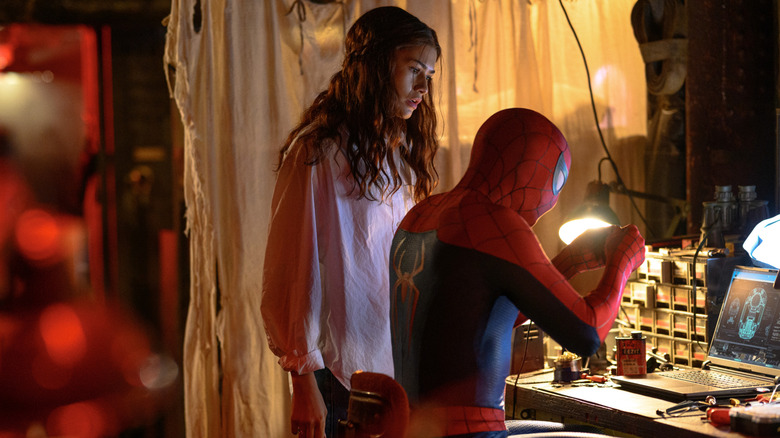 MJ looks on as Spider-Man tinkers with technology at a computer station in Spider-Man: Brand New Day