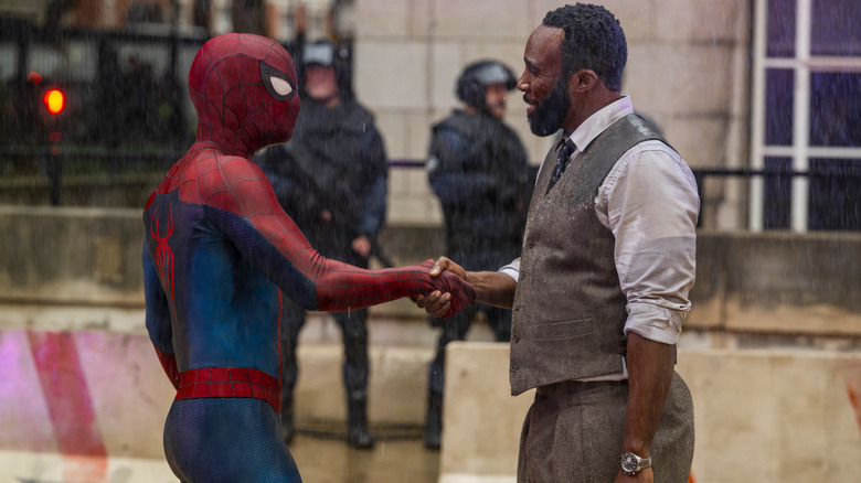 Tom Holland as Peter Parker wearing his superhero suit and shaking hands with Tramell Tillman as Bill Metzger in Spider-Man: Brand New Day
