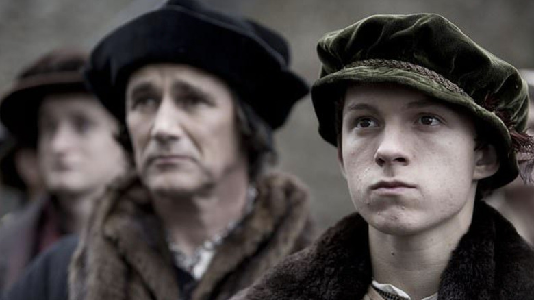 Mark Rylance as Thomas Cromwell standing next to Tom Holland as Gregory Cromwell in Wolf Hall
