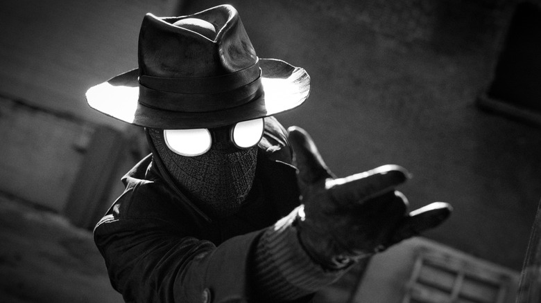 The Spider wearing a dark costume and about to shoot webbing out of his hands in Spider-Noir