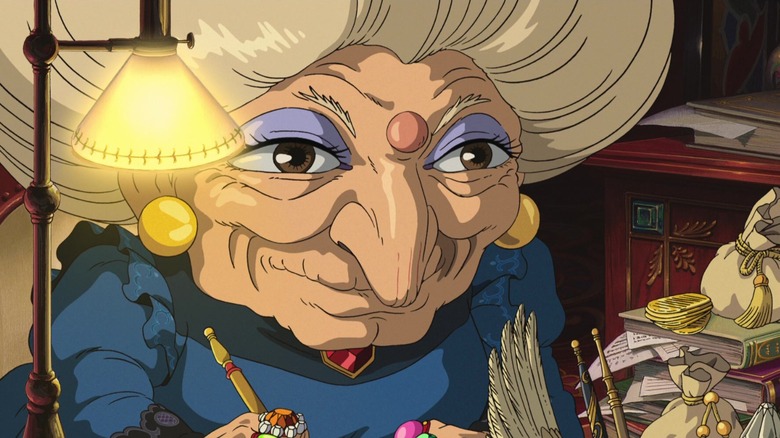 Yubaba smiling while holding a pen