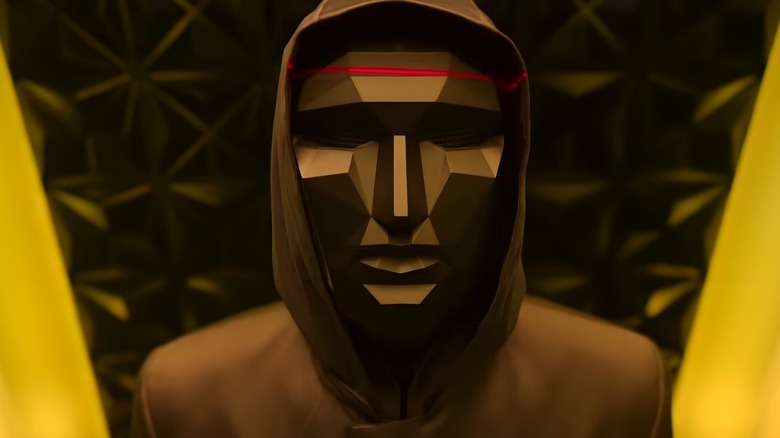 The front man standing in the black and yellow room in the Squid Game