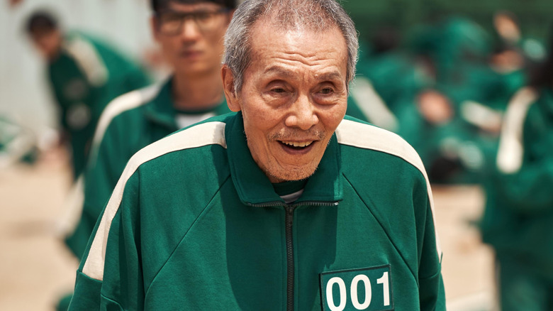 Il Nam is smiling and wearing his sportswear in Squid Game Season 1
