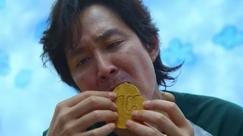 Lee Jung-jae's Seong Gi-hun licking a Dalgona candy on Squid Game