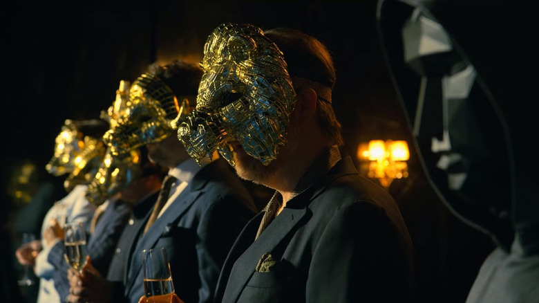 VIPs in gold masks standing next to the Front Man on Squid Game