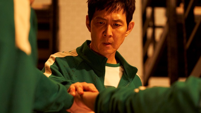 Gi-hun striking an alliance with some participants in Squid Game