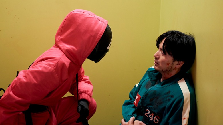 Guard 011 urging Player 246 to play dead in Season 3 of Squid Game