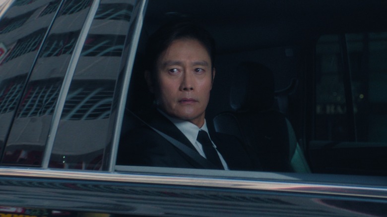 The Front Man sitting in a car looking out the window in Squid Game