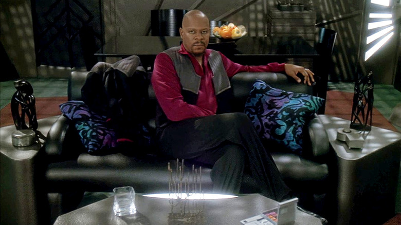 స్టార్ ట్రెక్: డీప్ స్పేస్ నైన్‌లో కెప్టెన్ బెంజమిన్ సిస్కోగా అవేరీ బ్రూక్స్, తన క్వార్టర్స్‌లో యూనిఫాం జాకెట్‌ను తీసివేసి, అతని చొక్కా విప్పి కూర్చున్నాడు