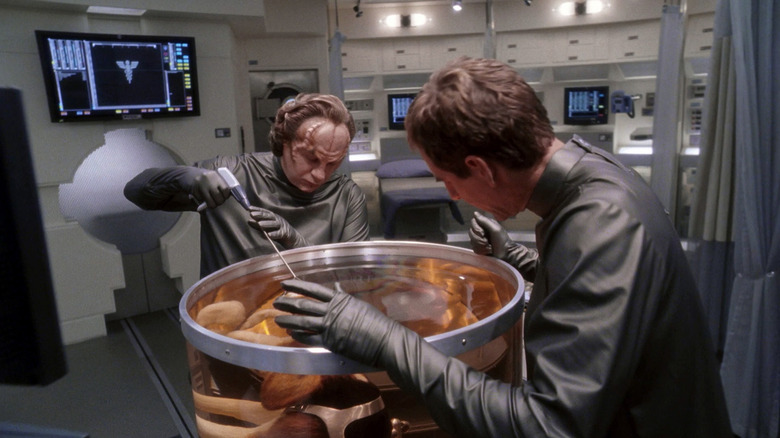 Dr -Flox working on a dog in a liquid tank while captain Archer looks at Star Trek: Enterprise