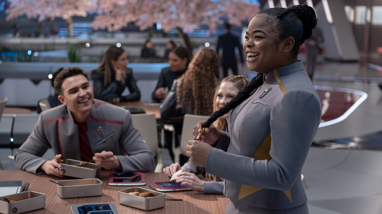 Sam smiling next to a able of friend in Star Trek: Starfleet Academy