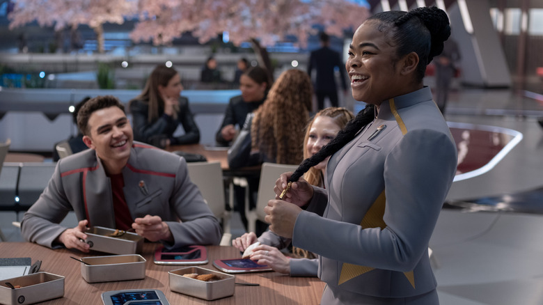 Sam smiling next to a able of friend in Star Trek: Starfleet Academy