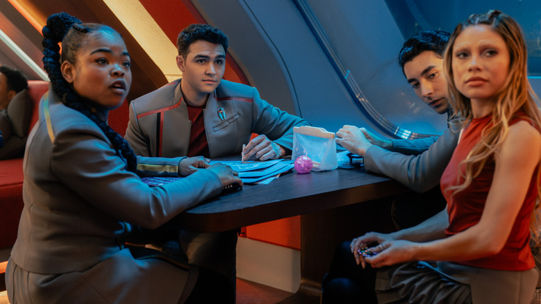 Kerrice Brooks' SAM, George Hawkins' Darem, Romeo Carere's Ocam, and Bella Shepard's Genesis sitting around a table on Star Trek: Starfleet Academy