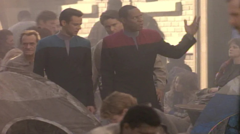 Alexander Siddig's Julian Bashir and Avery Brooks' Benjamin Sisko walking in a tent village on Star Trek: Deep Space Nine