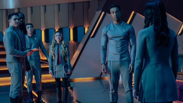 George Hawkins as Darem, Karim Diané as Jay-Den, Romeo Carere as Ocam, Bella Shepard as Genesis, and Sandro Rosta as Caleb standing in a room facing Zoë Steiner as Tarima in Star Trek: Starfleet Academy