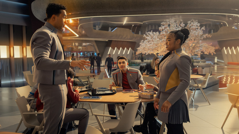 Sam en Caleb zijn aan het schuldenen bij een tafel in de kantine in Star Trek: Starfleet Academy