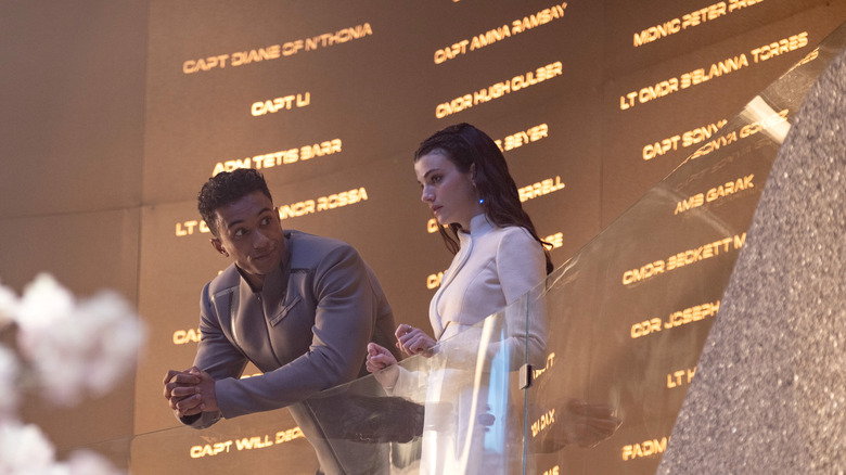 Two Starfleet Academy cadets standing in front of a large wall of names on Star Trek: Starfleet Academy