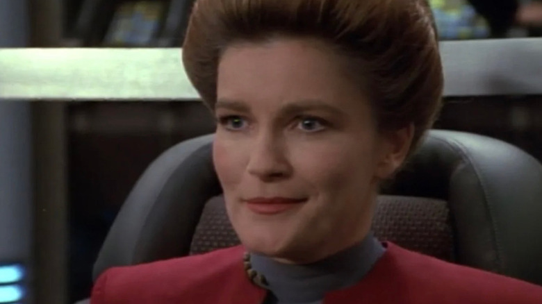 Kate Mulgrew as Kathryn Janeway looking pleased in Star Trek: Voyager